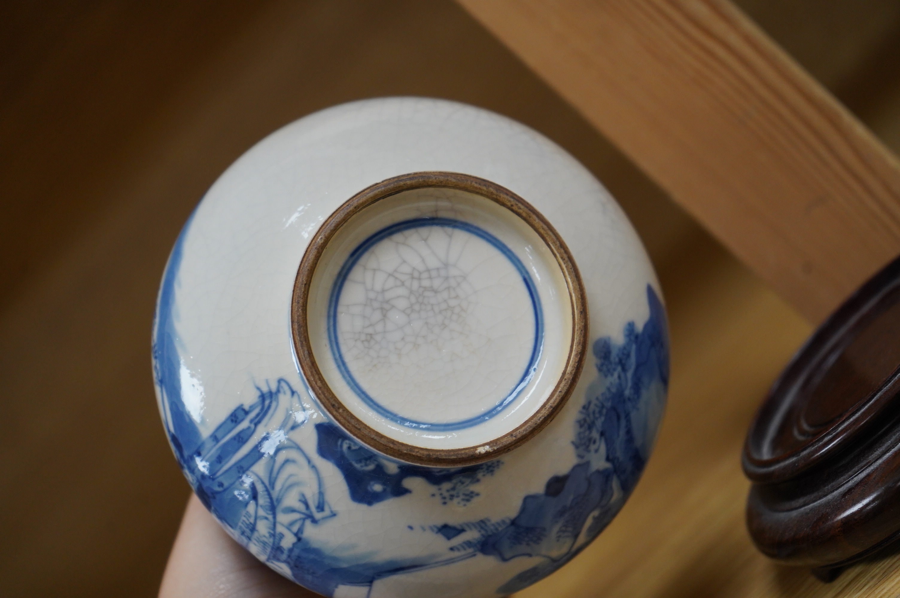 A 19th century Chinese blue and white crackle glaze bottle vase on hardwood stand, 20cm total. Condition - firing cracks to neck interior